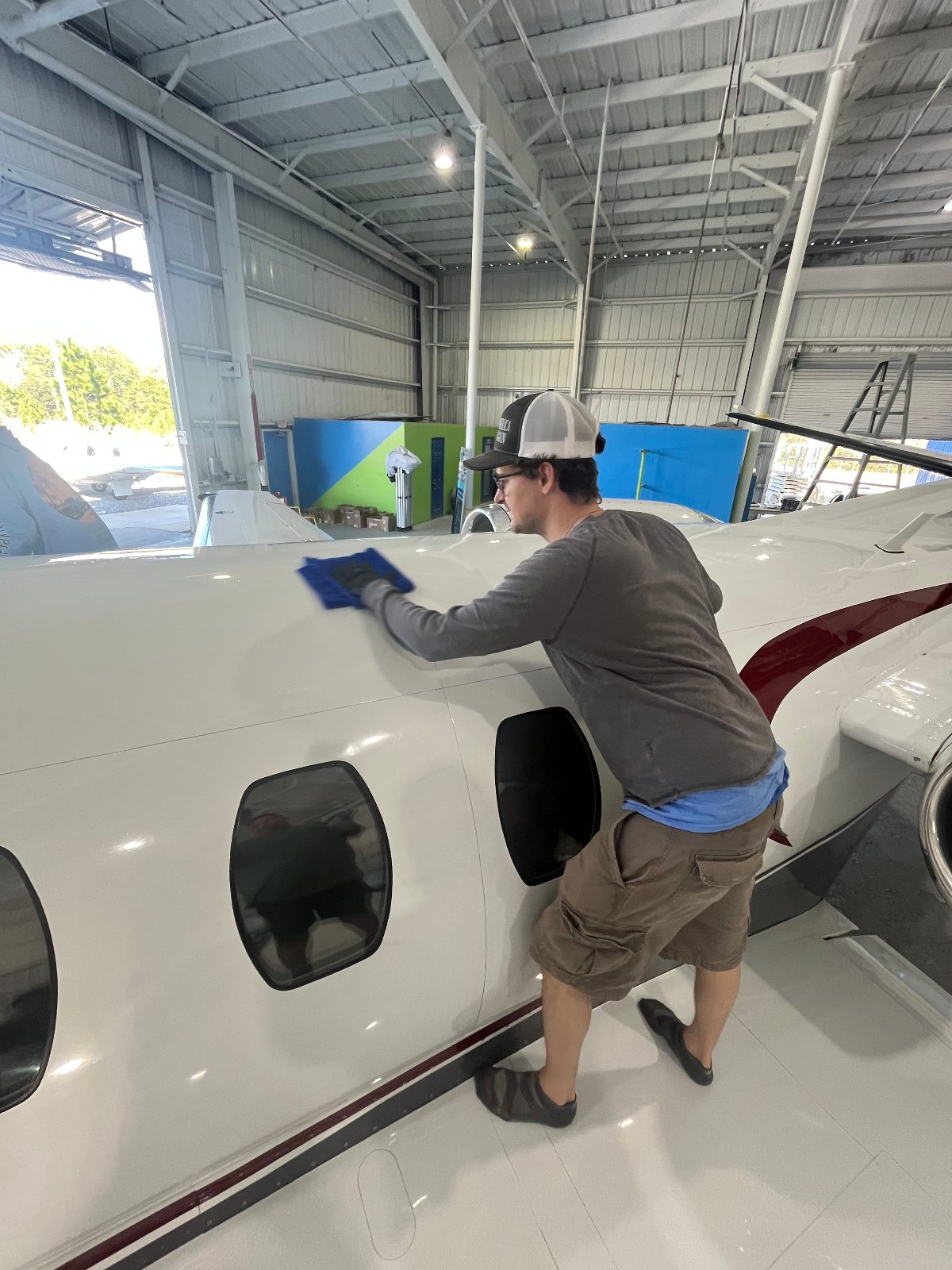 Hand-detailing a business jet fuselage in the hangar